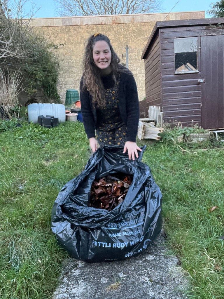 Author, Poppy, showing the bag of leaves given to her by the road workers.